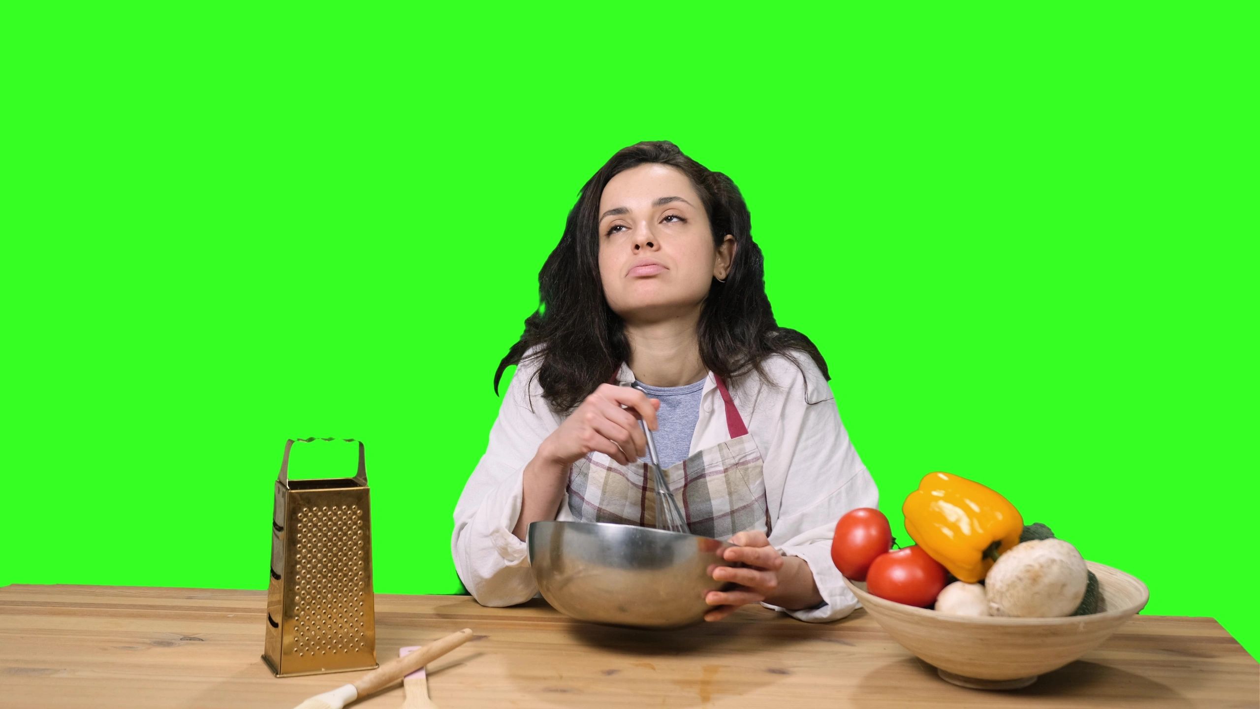 Tired young woman sitting at the table, cooking.